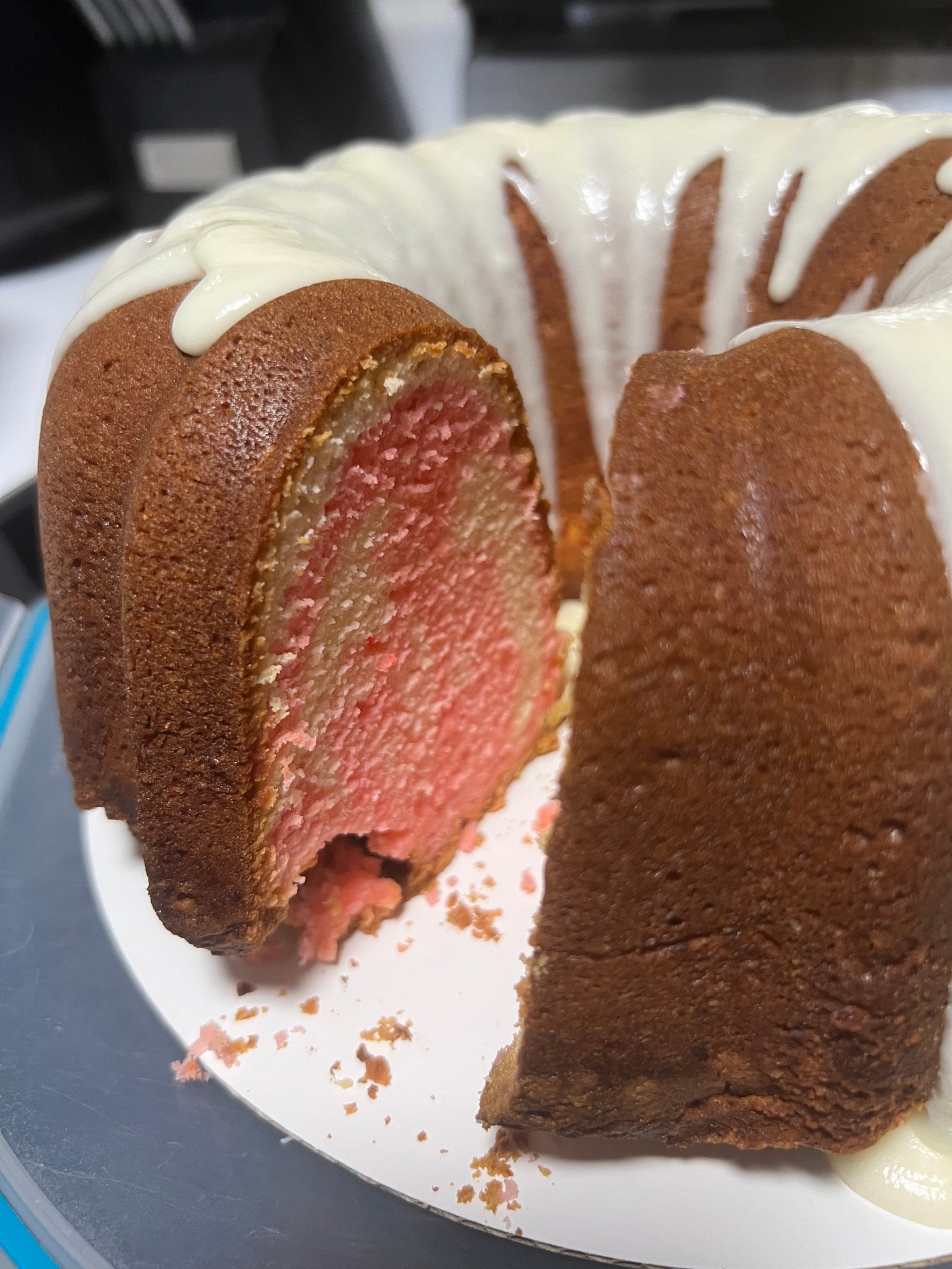 Strawberry pound cake with white chocolate drizzle, sliced to show pink interior